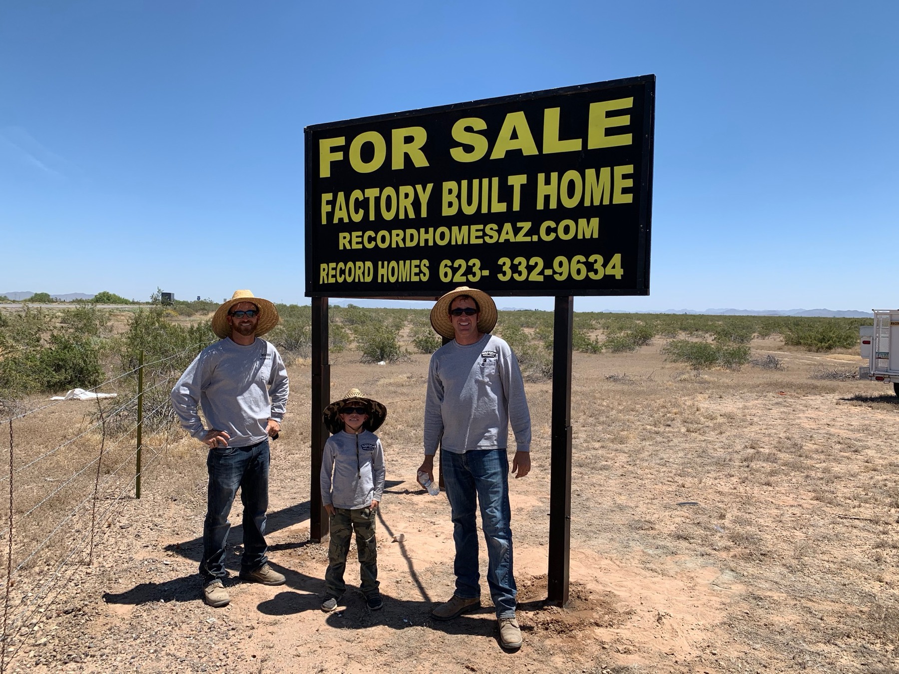 Three generations of the Record family under a Record Homes for-sale sign