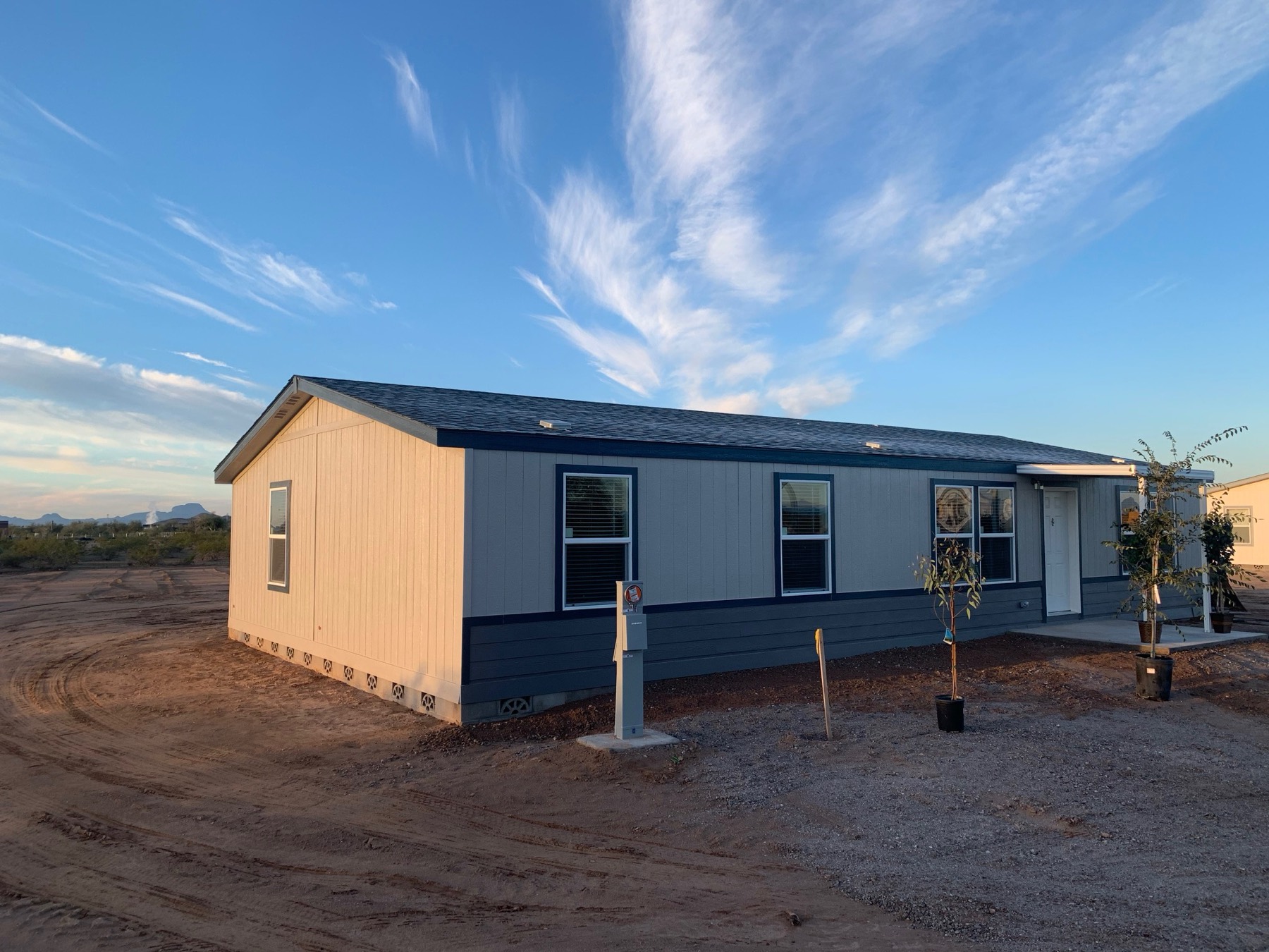 New home with navy trim on an acre lot under a big Arizona sky